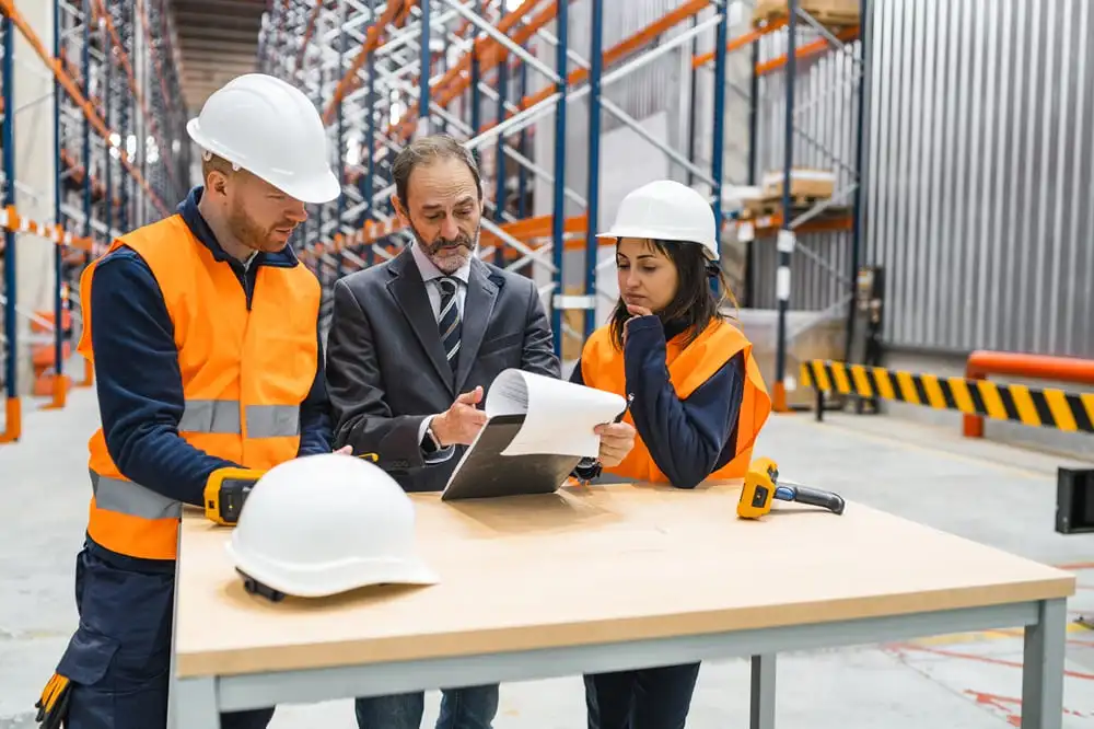 Inspector de seguridad laboral revisando cumplimiento del Real Decreto 486/97 en lugar de trabajo moderno