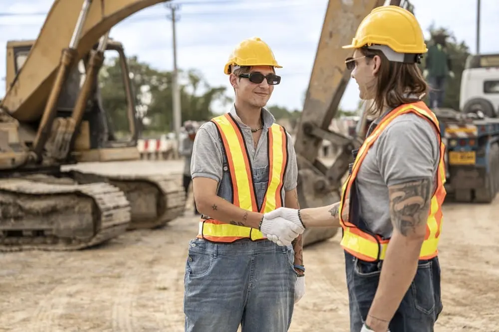 Reunión de profesionales empresarios discutiendo subcontratación y cumplimiento Ley 32/2006 en España con documentos PRL