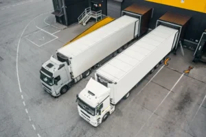 Gestión coordinada de múltiples transportistas autónomos en muelles de carga de centro logístico 24/7 con control CAE