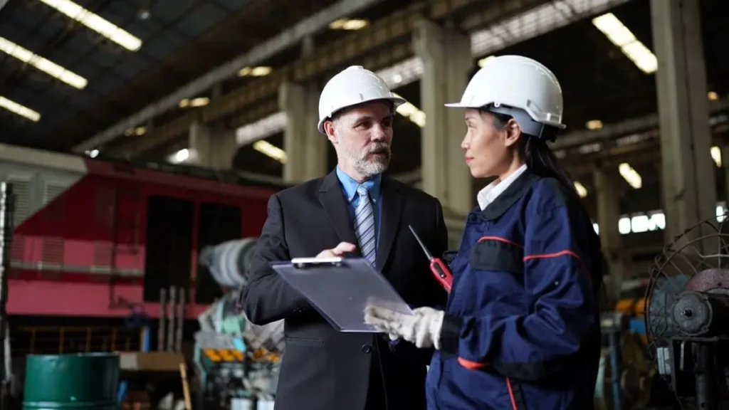 Inspector de trabajo revisando documentación con encargada de fábrica durante una visita de inspección