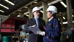 Inspector de trabajo revisando documentación con encargada de fábrica durante una visita de inspección