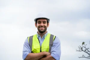 Contratista con chaleco de alta visibilidad y casco de seguridad, sonriendo, representando la gestión documental CAE en Twind