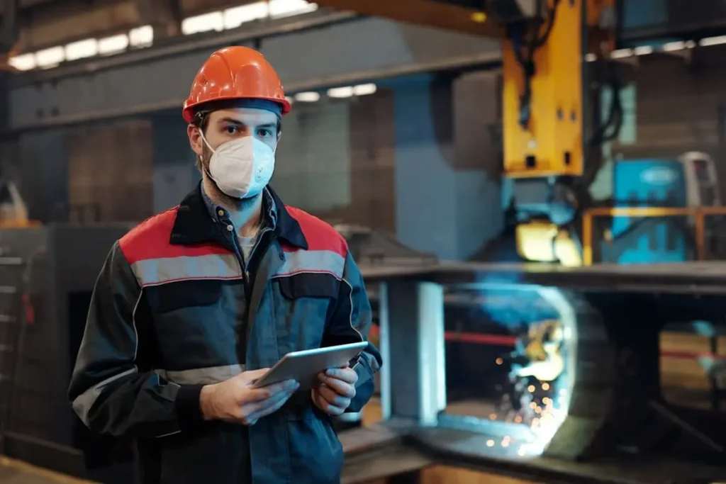 Guía para contratar un software CAE - técnico de PRL con casco revisando en una tablet el cumplimiento de contratistas en planta industrial
