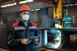 Guía para contratar un software CAE - técnico de PRL con casco revisando en una tablet el cumplimiento de contratistas en planta industrial