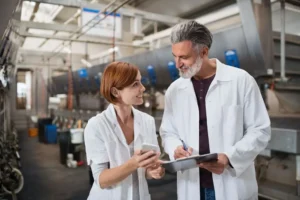 Ispettore aziendale esegue controllo qualità fornitori con checklist in magazzino industriale