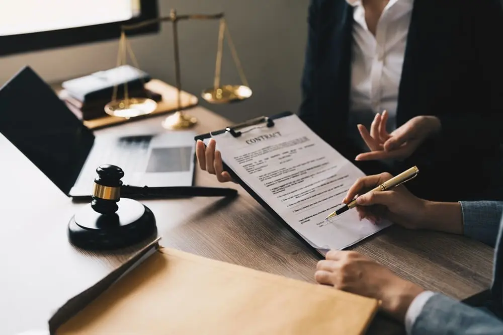 Responsabilità solidale negli appalti - Stretta di mano tra committente e appaltatore con documenti contrattuali e caschi di sicurezza