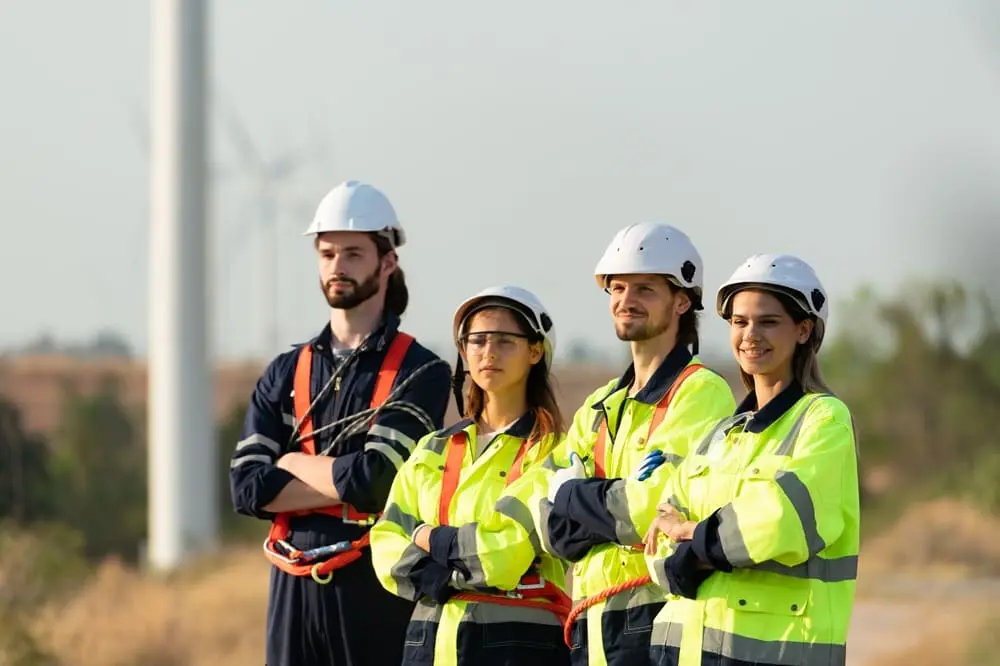 Gruppo di lavoratori con DPI per prevenzione infortuni lavoro - caschi bianchi e giubbotti ad alta visibilità