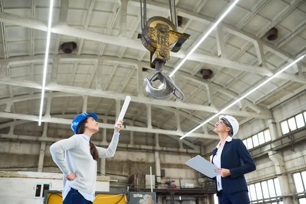 Verifica idoneità tecnico professionale ITP: RSPP e HSE Manager ispezionano attrezzature di sollevamento in cantiere industriale con documenti e checklist di sicurezza