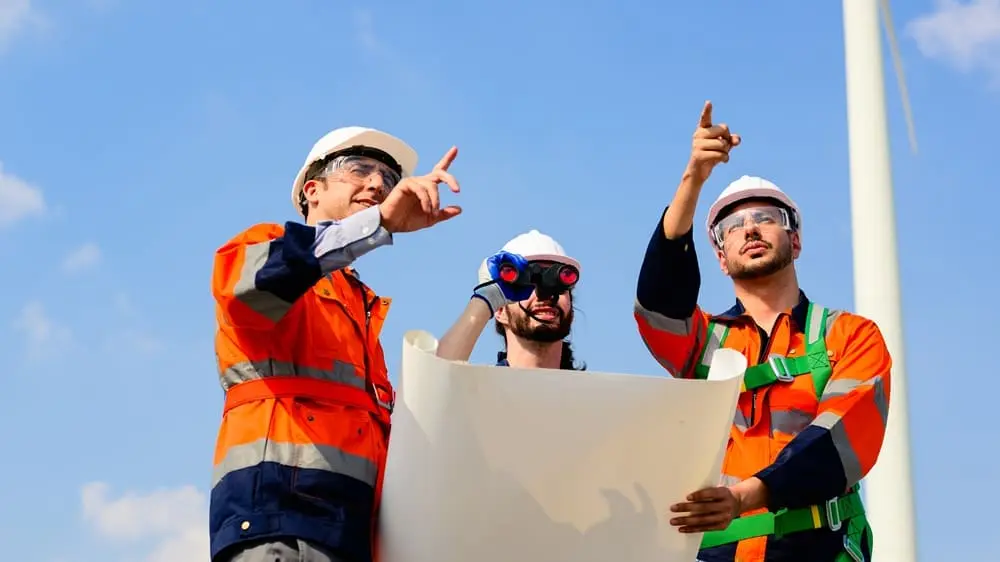 Near miss prevenzione: team sicurezza lavoro in cantiere con caschi e DPI analizza planimetrie gestione rischi