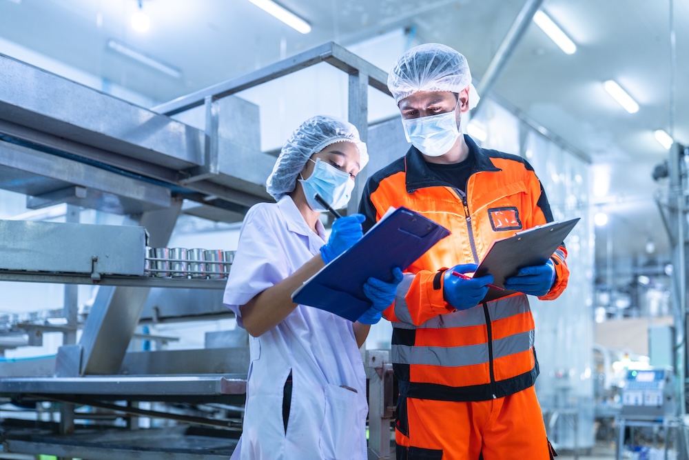 Un ispettore verifica la documentazione di una lavoratrice durante un audit SMETA in uno stabilimento.