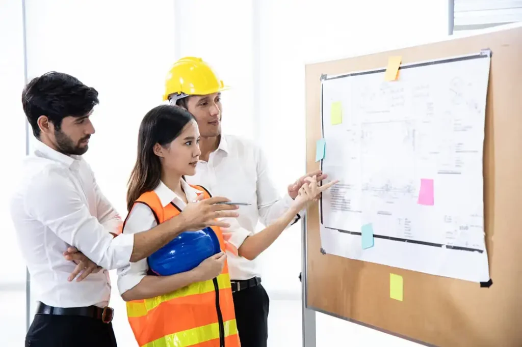 Equipo directivo mexicano revisando plan de seguridad empresarial en sala de juntas con cascos y documentos
