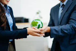 Profissionais segurando globo verde simbolizando sustentabilidade e alterações climáticas na norma ISO 45001:2027 para empresas portuguesas