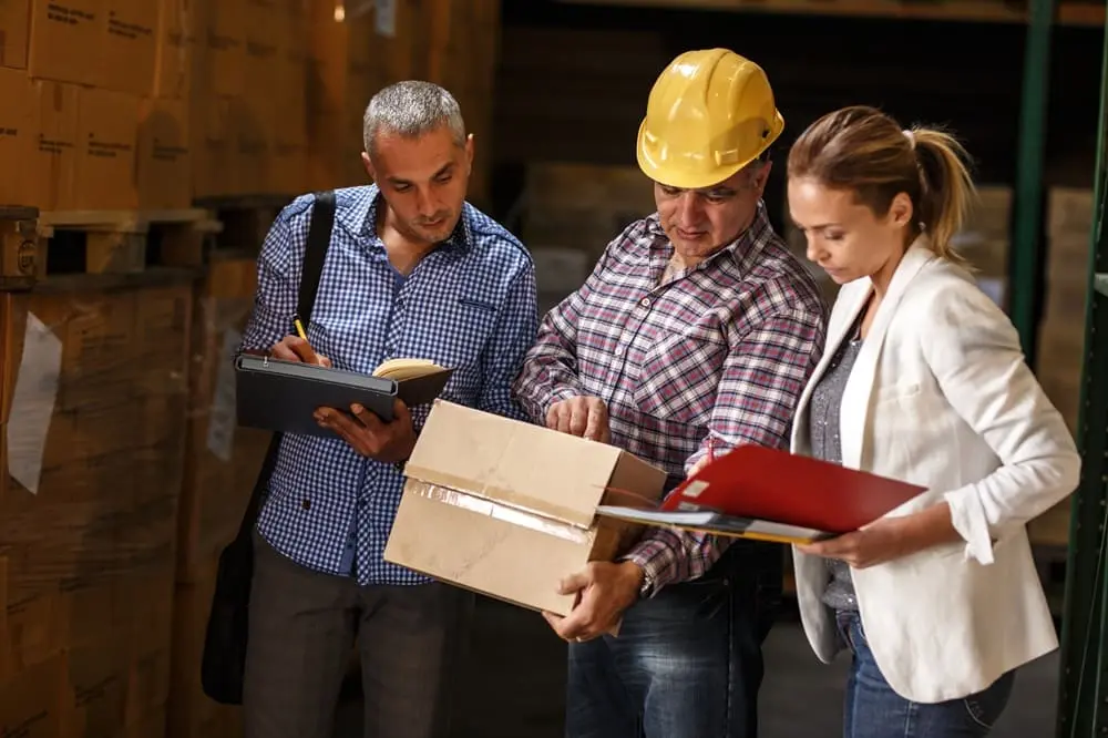 Responsável SST e subcontratados a verificar documentação em armazém industrial em Portugal
