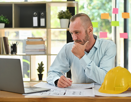 Health and safety manager reviewing contractor workers' training from their workstation